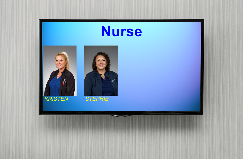 A wall-mounted monitor displays two nurses’ names and images.